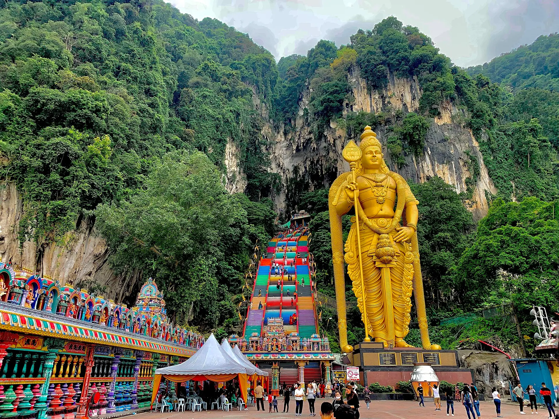 The colourful rainbow staircase leading up to the Temple Cave at Batu Caves, with the golden Murugan statue alongside
