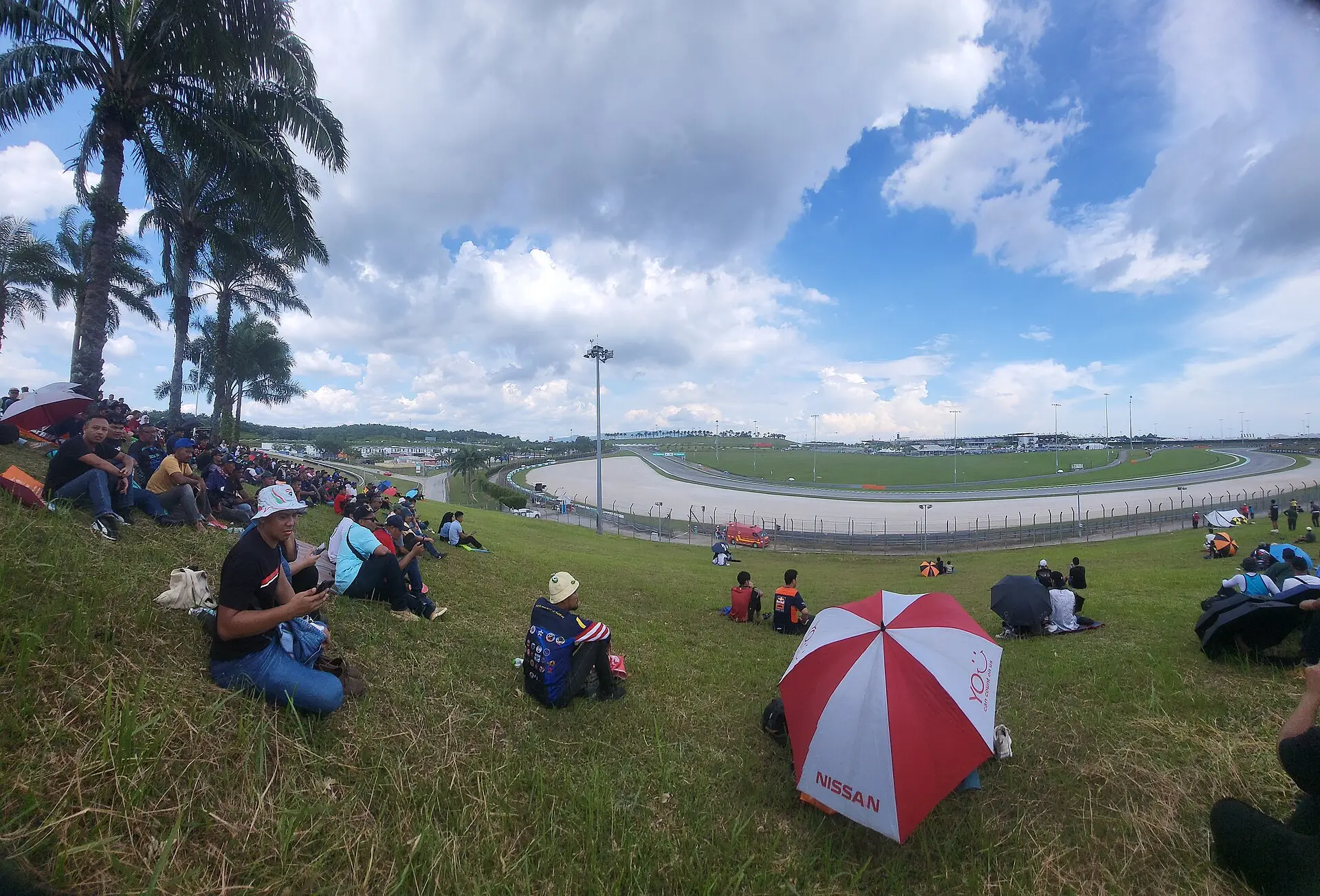 Spectators watching from the grass banking above the track at Sepang International Circuit